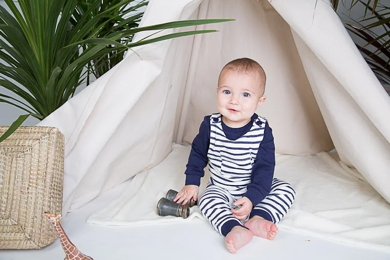 Baby greift nach einer Spielzeug-Ananas