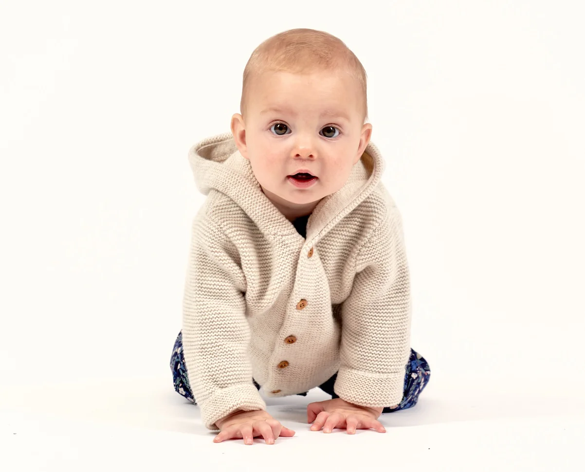 Baby im Cardigan krabbelt