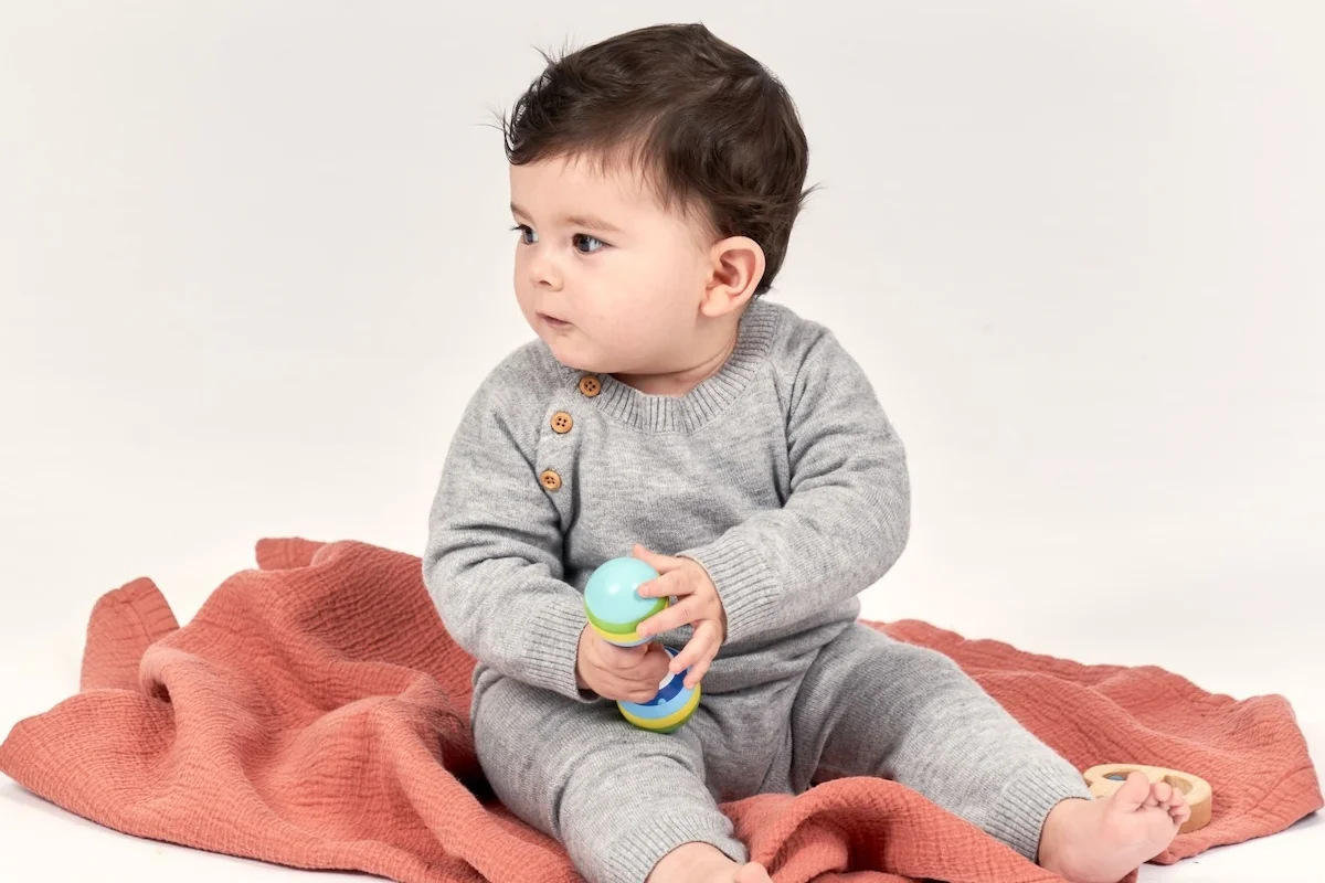 Baby sitzt auf einer kuscheligen Decke