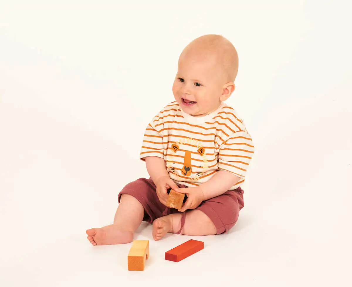 Baby mit Spielkl&ouml;tzen in der Hand