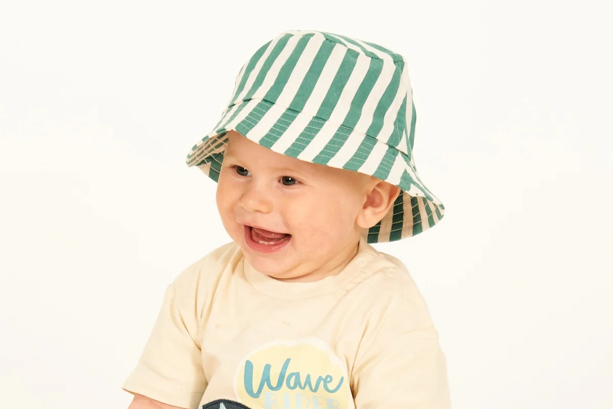 Baby mit Sonnehut und Spielzeugringen