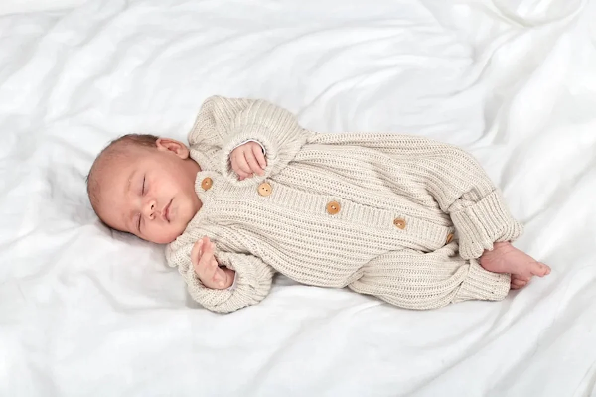 Baby schläft im Strickstrampler