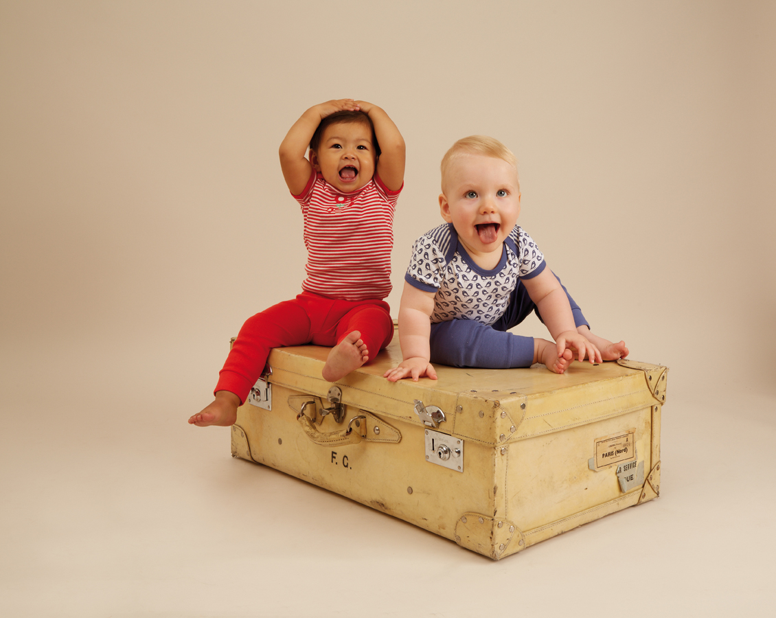 Zwei Babys sitzen auf einer Holzkiste