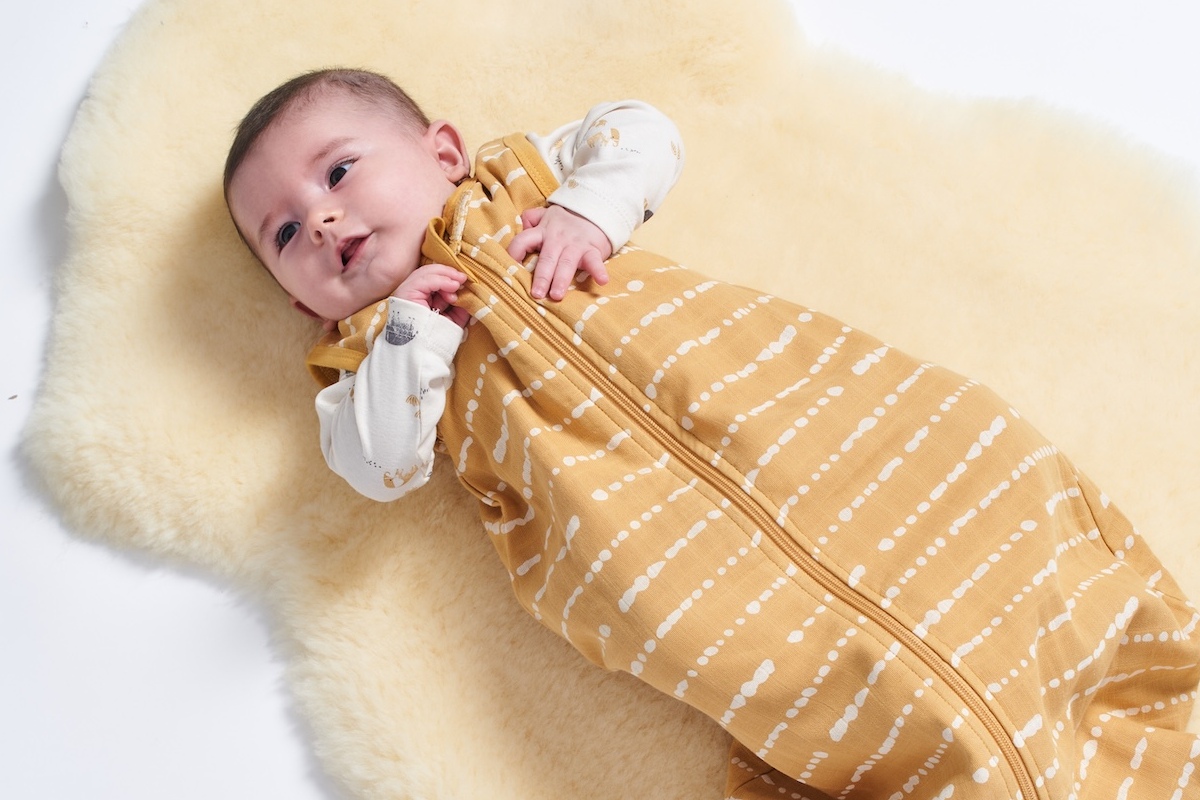 Baby im Schlafsack auf Lammfell