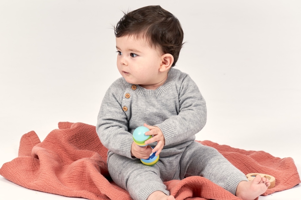 Baby sitzt auf einer kuscheligen Decke