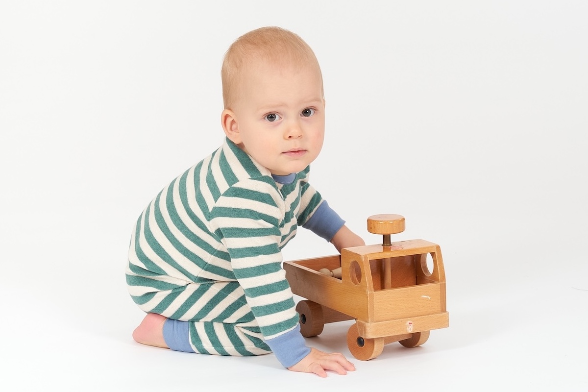 Baby  spielt mit Unimog aus Holz