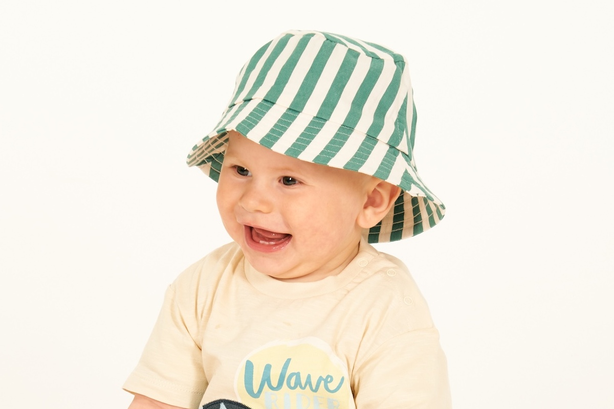 Baby mit Sonnehut und Spielzeugringen