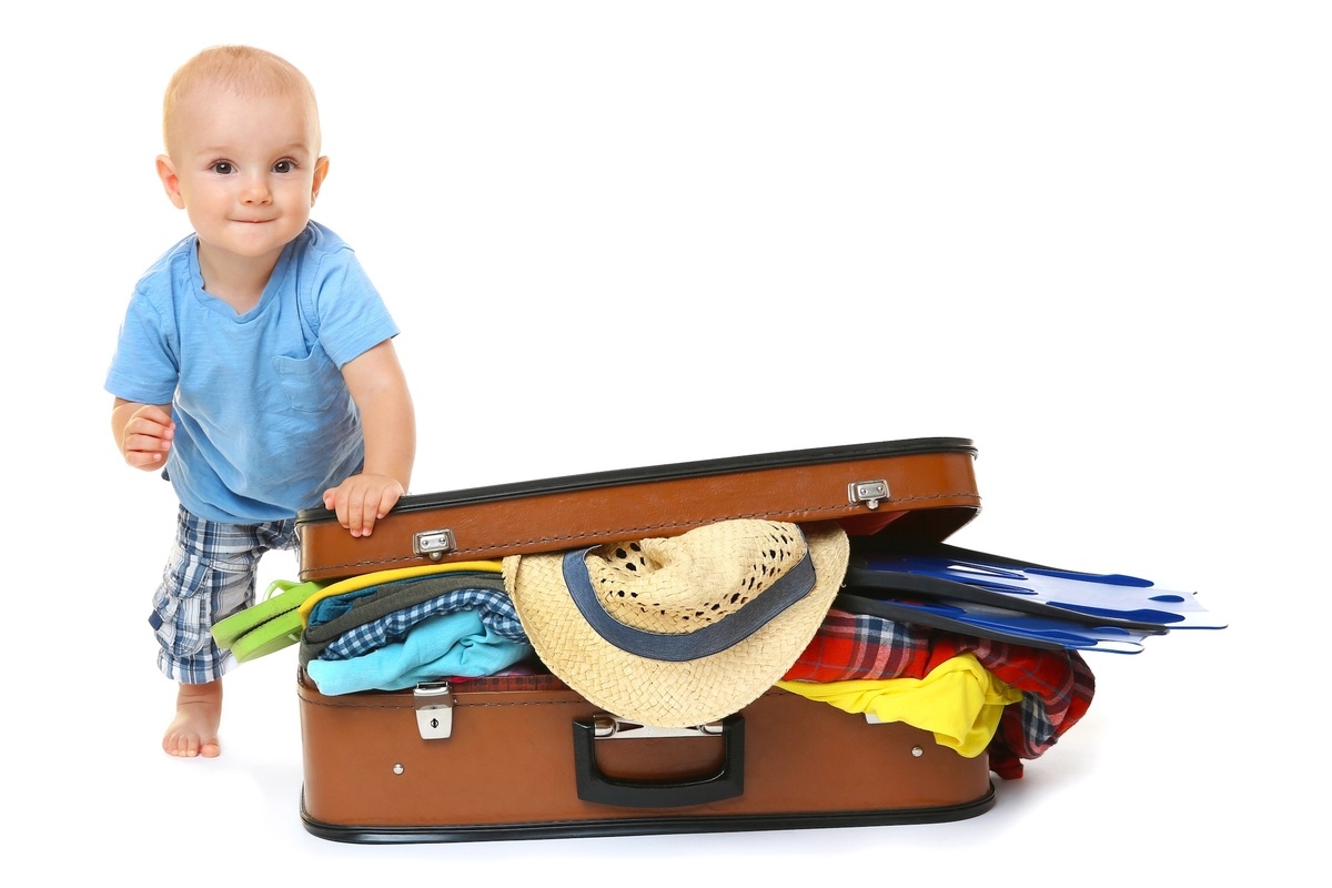 Baby st&uuml;tzt sich auf einen Reisekoffer