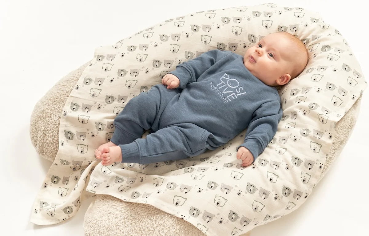Baby liegt auf großem Kissen